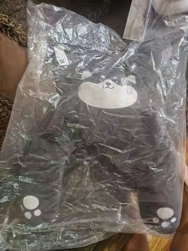 Customer photo of a dark gray RideNuzzle travel pillow in its packaging.