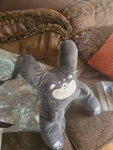 Customer photo of a dark gray RideNuzzle travel pillow on a sofa.